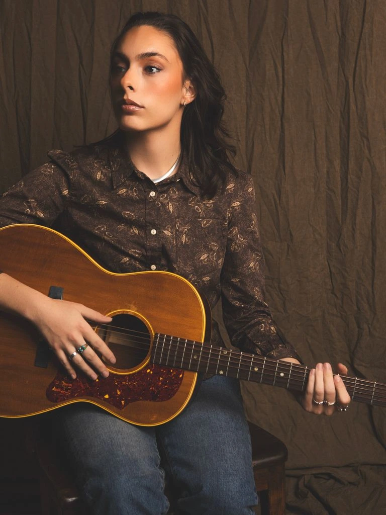 Laura Marling seated with an acoustic guitar in an English countryside parlor, photographed for this issue's feature essay.
